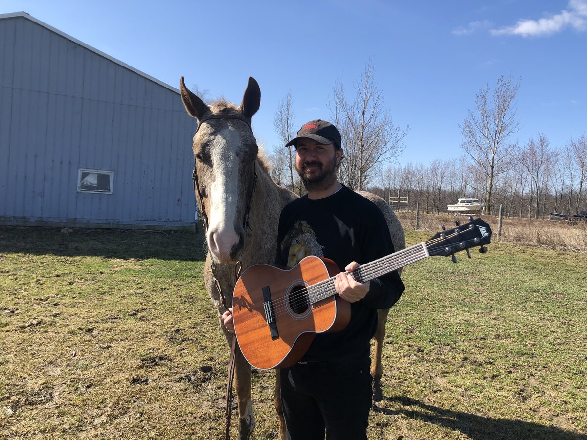 Chris with acoustic guitar, smiling